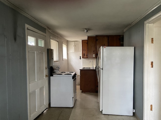 kitchen with light tile patterned flooring, white appliances, ornamental molding, and sink