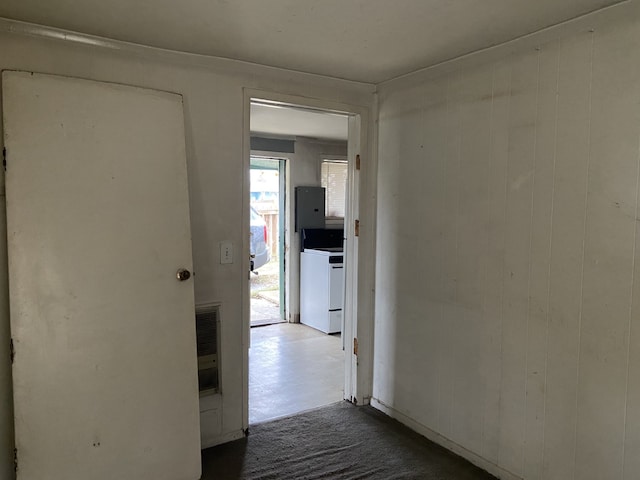 hall featuring wood walls, washer / clothes dryer, and electric panel