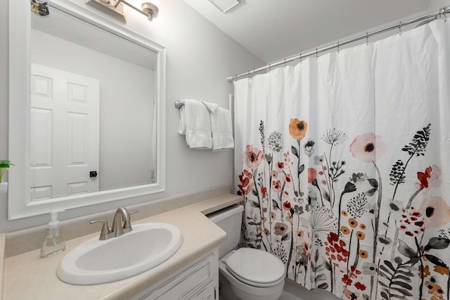 bathroom featuring toilet, vanity, and a shower with shower curtain