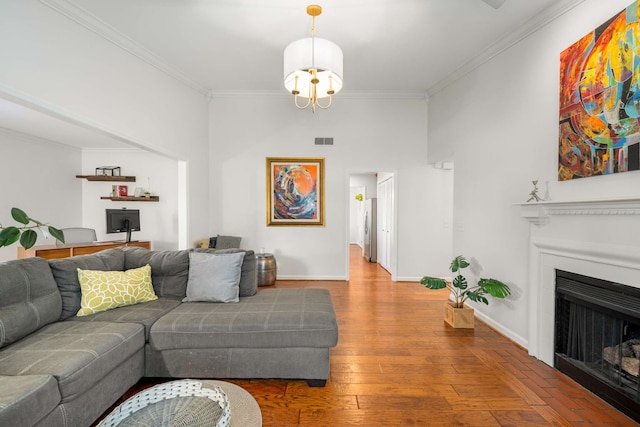 living room with a chandelier, wood-type flooring, and ornamental molding