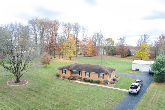 ranch-style home featuring a garage, an outbuilding, and a front yard