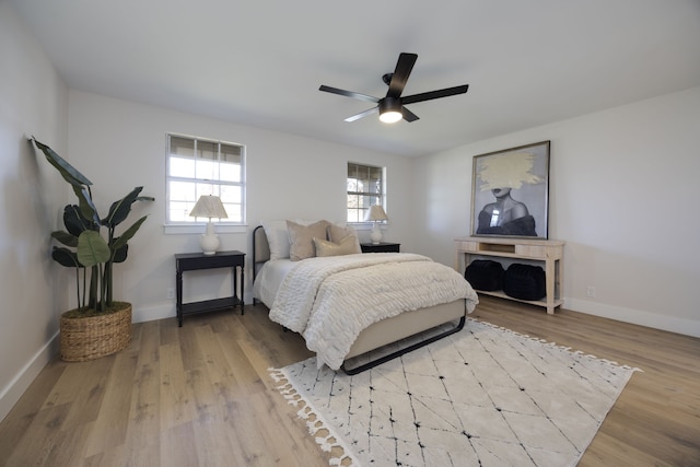 bedroom with light wood-type flooring, multiple windows, and ceiling fan