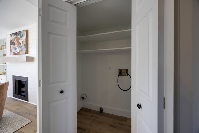 laundry area with a fireplace, washer hookup, and hardwood / wood-style flooring