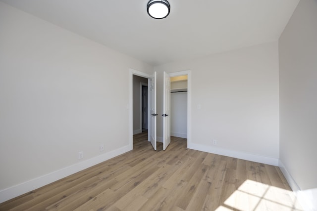 unfurnished bedroom with a closet and light hardwood / wood-style flooring