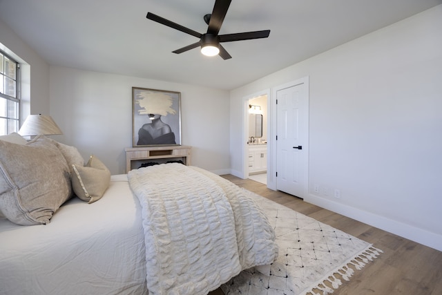 bedroom with hardwood / wood-style floors, ceiling fan, and ensuite bath