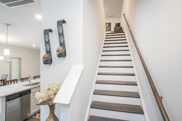 staircase featuring hardwood / wood-style floors and sink