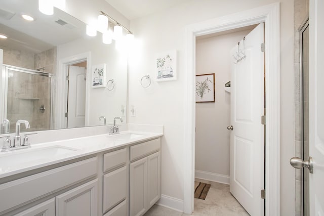 bathroom with vanity and a shower with door