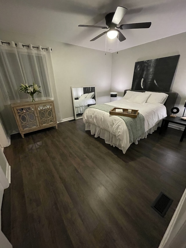 bedroom with dark hardwood / wood-style floors and ceiling fan