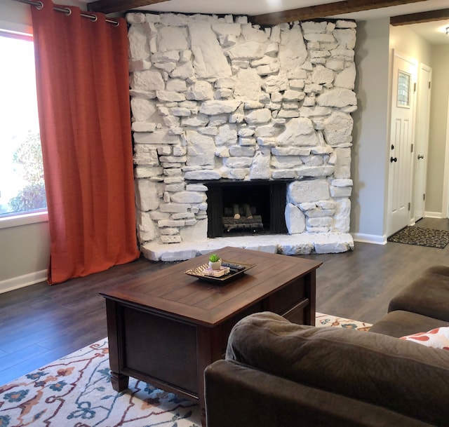 living room with a fireplace, wood-type flooring, a wealth of natural light, and beamed ceiling