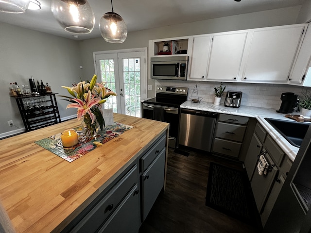 kitchen with pendant lighting, gray cabinetry, white cabinets, butcher block counters, and stainless steel appliances