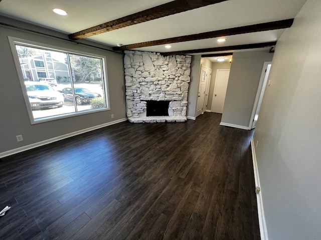 unfurnished living room featuring a fireplace, beamed ceiling, and dark hardwood / wood-style floors