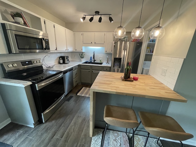 kitchen featuring pendant lighting, backsplash, sink, and stainless steel appliances