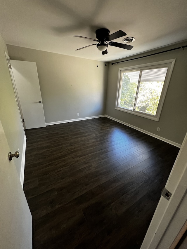 spare room with ceiling fan and dark wood-type flooring