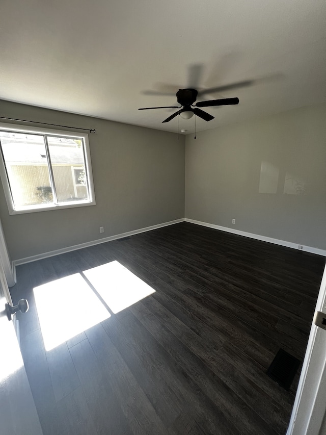 spare room featuring ceiling fan and dark wood-type flooring