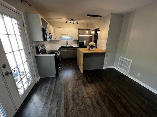 kitchen featuring sink, stainless steel appliances, wood counters, dark hardwood / wood-style floors, and decorative light fixtures