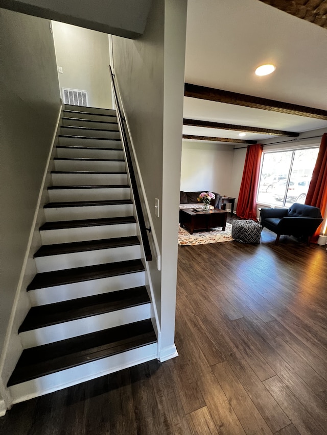 stairway with hardwood / wood-style floors and beamed ceiling