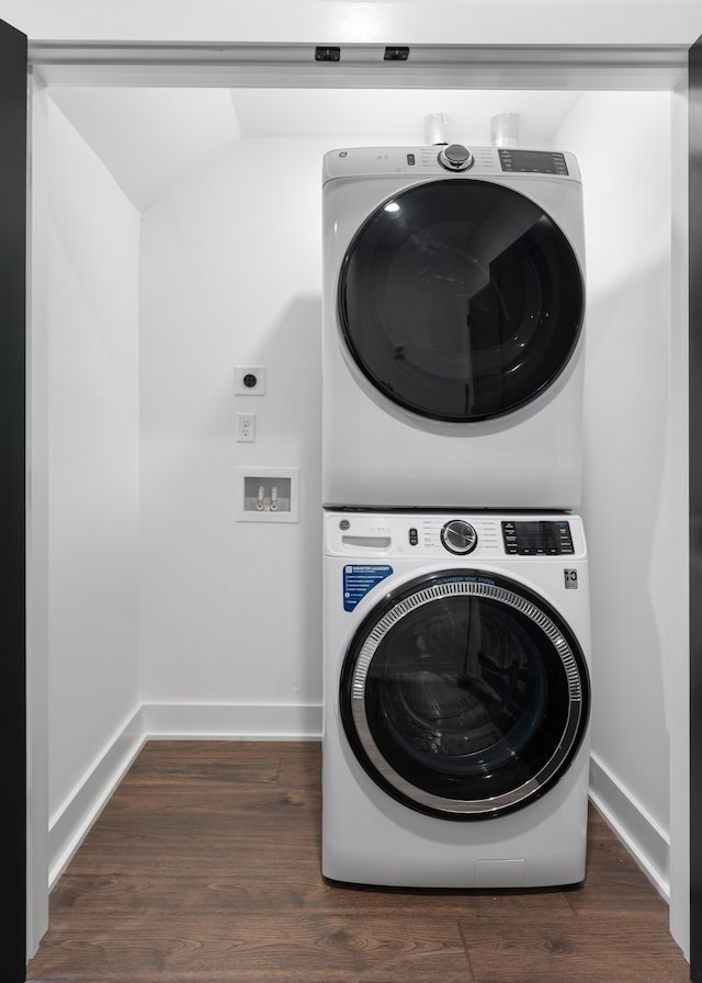 clothes washing area with stacked washer / dryer and dark hardwood / wood-style floors