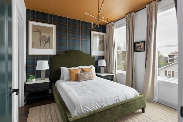 bedroom featuring wood-type flooring and a notable chandelier