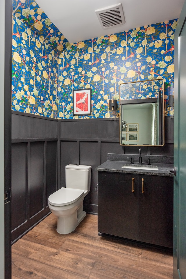 bathroom with hardwood / wood-style floors, vanity, and toilet