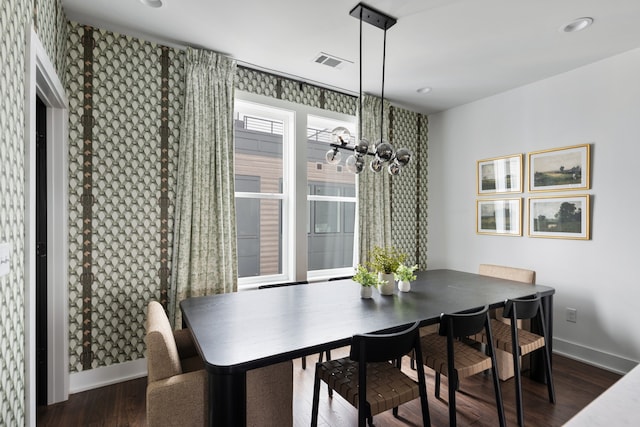 dining space with dark wood-type flooring and a chandelier