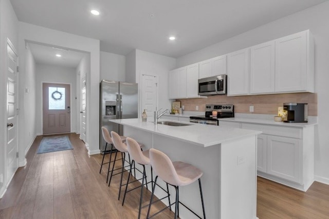 kitchen with sink, white cabinetry, an island with sink, and appliances with stainless steel finishes