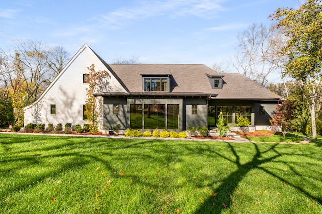 rear view of house featuring a yard