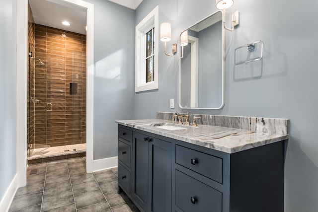 bathroom featuring tile patterned flooring, vanity, and tiled shower