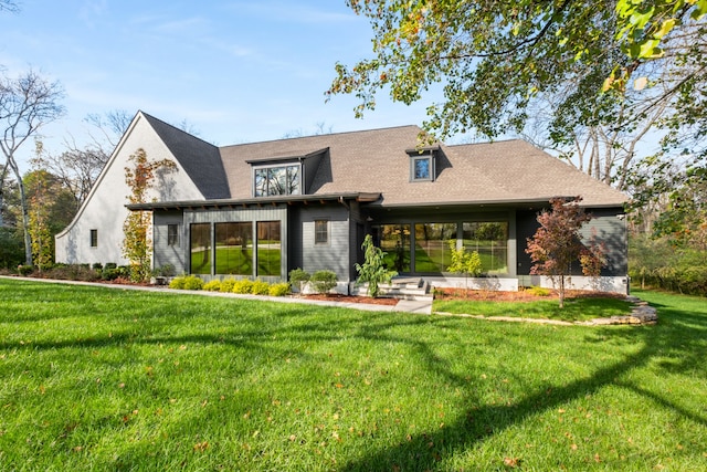 rear view of property featuring a yard and a sunroom