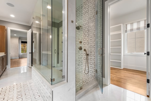 bathroom with hardwood / wood-style floors, a shower with door, and crown molding