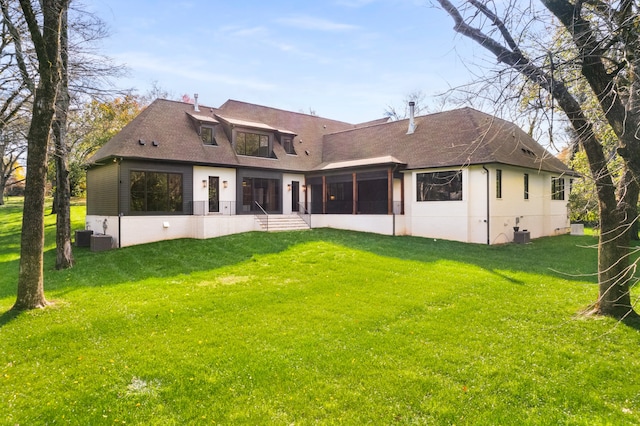 back of property with a yard and a sunroom