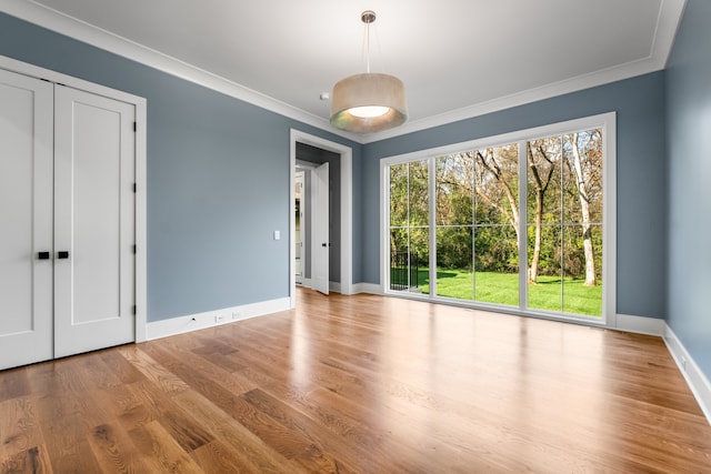 empty room with ornamental molding and light wood-type flooring