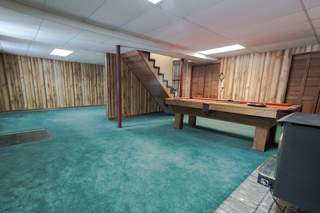 game room with dark colored carpet, a paneled ceiling, wooden walls, and pool table