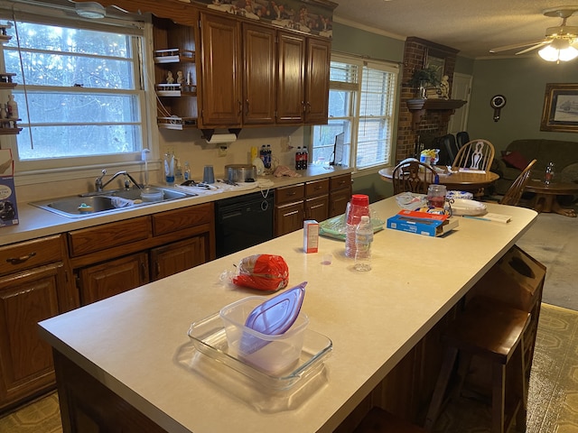 kitchen with black dishwasher, a breakfast bar area, a healthy amount of sunlight, and sink