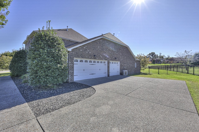 view of home's exterior with a lawn, central AC, and a garage