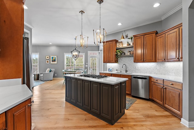 kitchen featuring a center island, sink, appliances with stainless steel finishes, decorative light fixtures, and light hardwood / wood-style floors