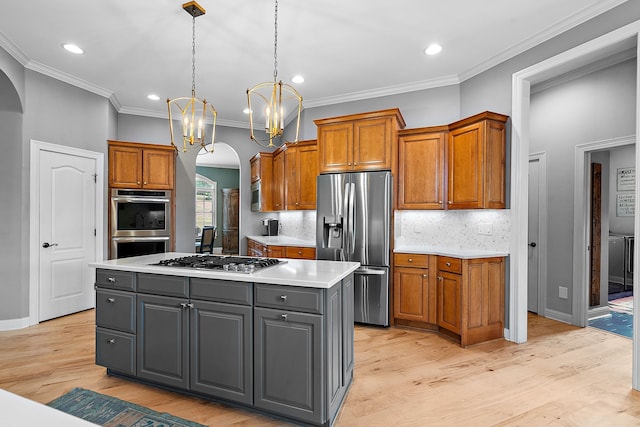 kitchen with a center island, an inviting chandelier, gray cabinets, light hardwood / wood-style floors, and stainless steel appliances