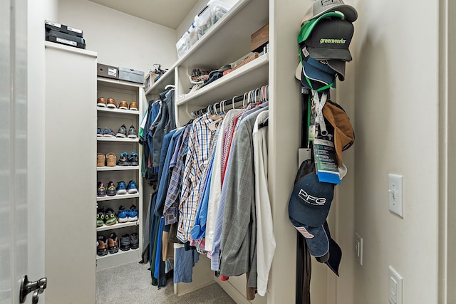 walk in closet featuring light colored carpet