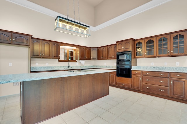 kitchen featuring pendant lighting, a high ceiling, black appliances, light tile patterned floors, and a kitchen island