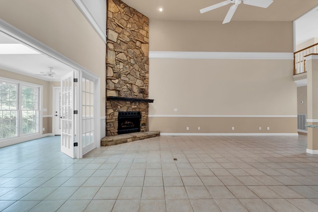 unfurnished living room with a fireplace, ceiling fan, and light tile patterned flooring