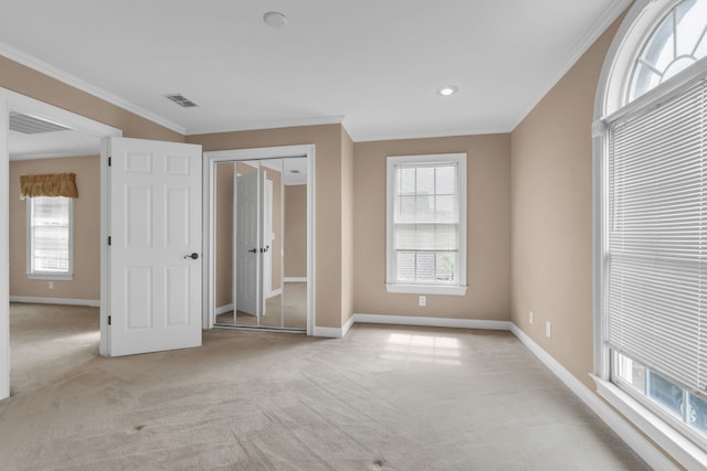 unfurnished bedroom with light colored carpet and crown molding