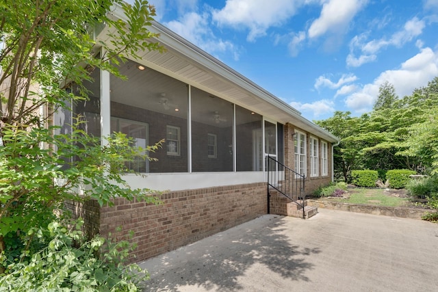 view of side of home featuring a sunroom and a patio