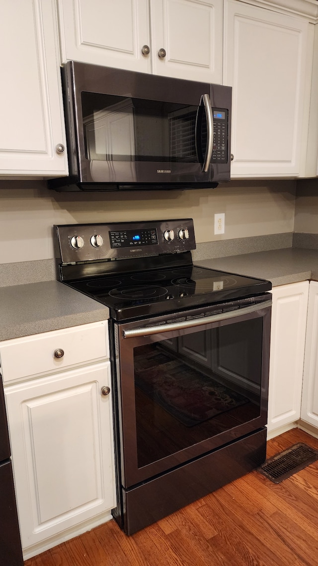 kitchen featuring white cabinetry, light hardwood / wood-style floors, and appliances with stainless steel finishes