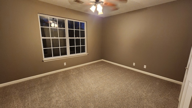 carpeted spare room featuring ceiling fan