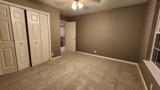 unfurnished bedroom with carpet flooring, ceiling fan, and a closet