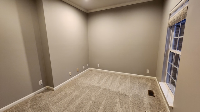 carpeted empty room featuring crown molding