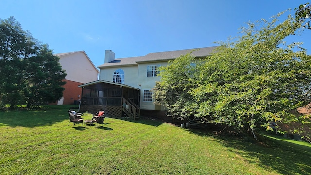 back of property featuring a sunroom and a yard