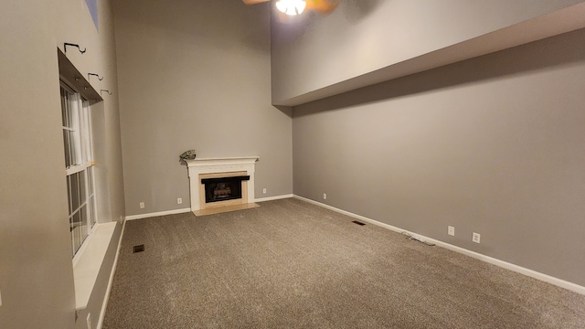 unfurnished living room with carpet flooring and ceiling fan