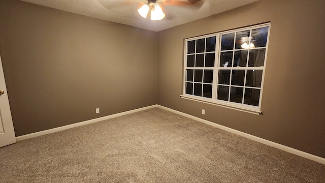 carpeted spare room featuring ceiling fan