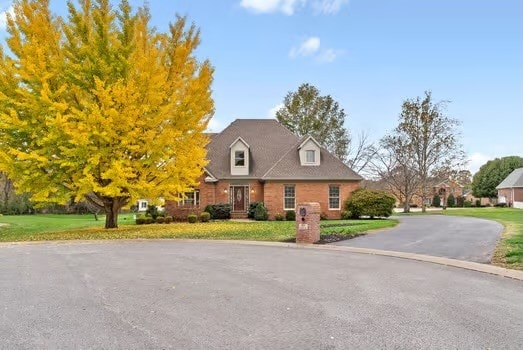 new england style home featuring a front lawn