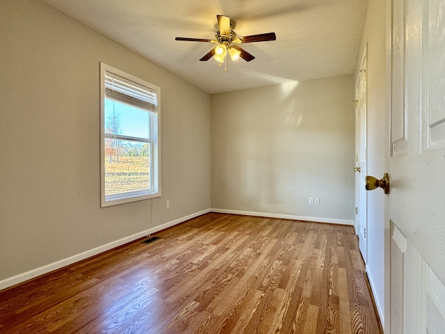 unfurnished room with ceiling fan, light wood-type flooring, and a textured ceiling